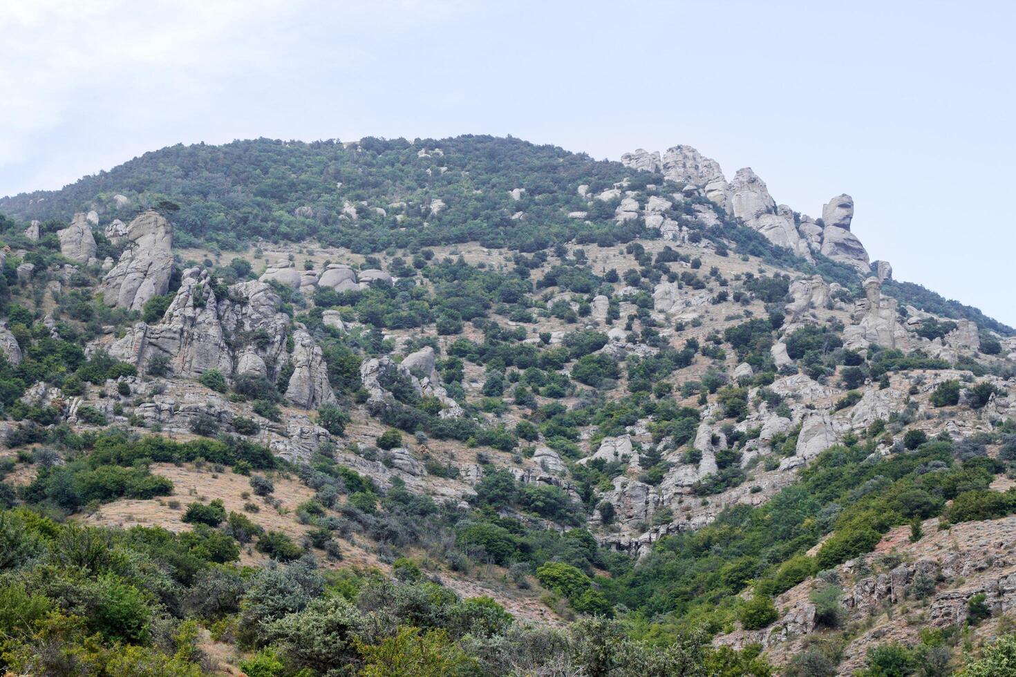 A scenic view of a rugged mountain landscape under a dramatic cloudy sky. photo