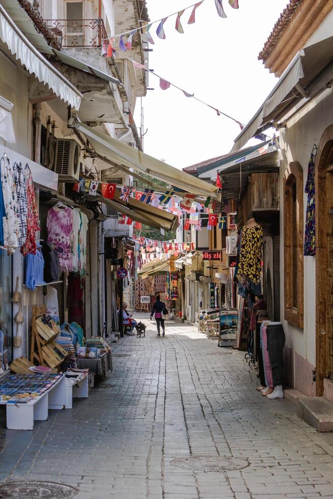 Antalya, Turkey - November 15, 2022. Narrow alleyway in a town with colorful flags and shops. photo