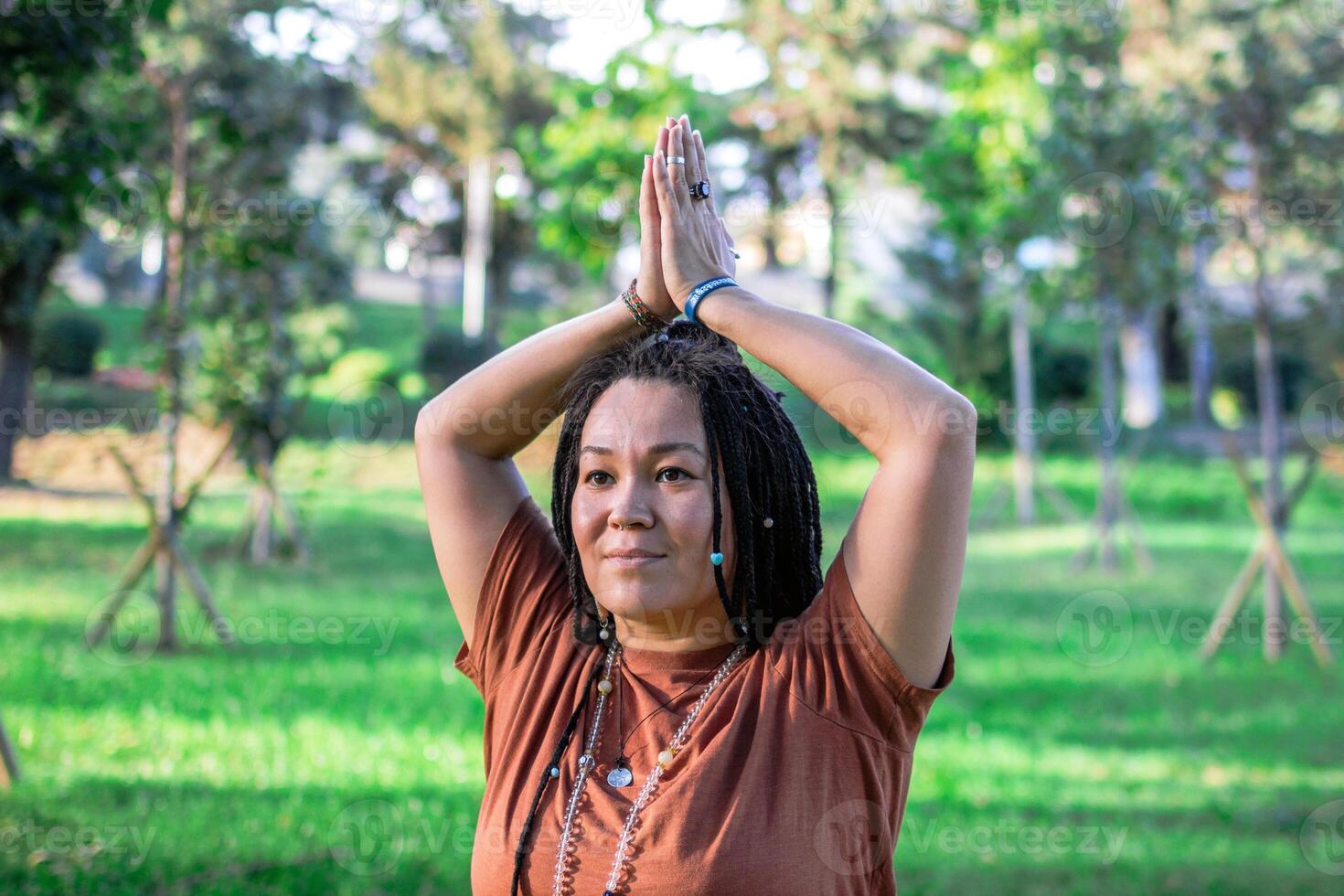 Woman is doing yoga exercise outside in a park. Concept of healthy lifestyle. photo