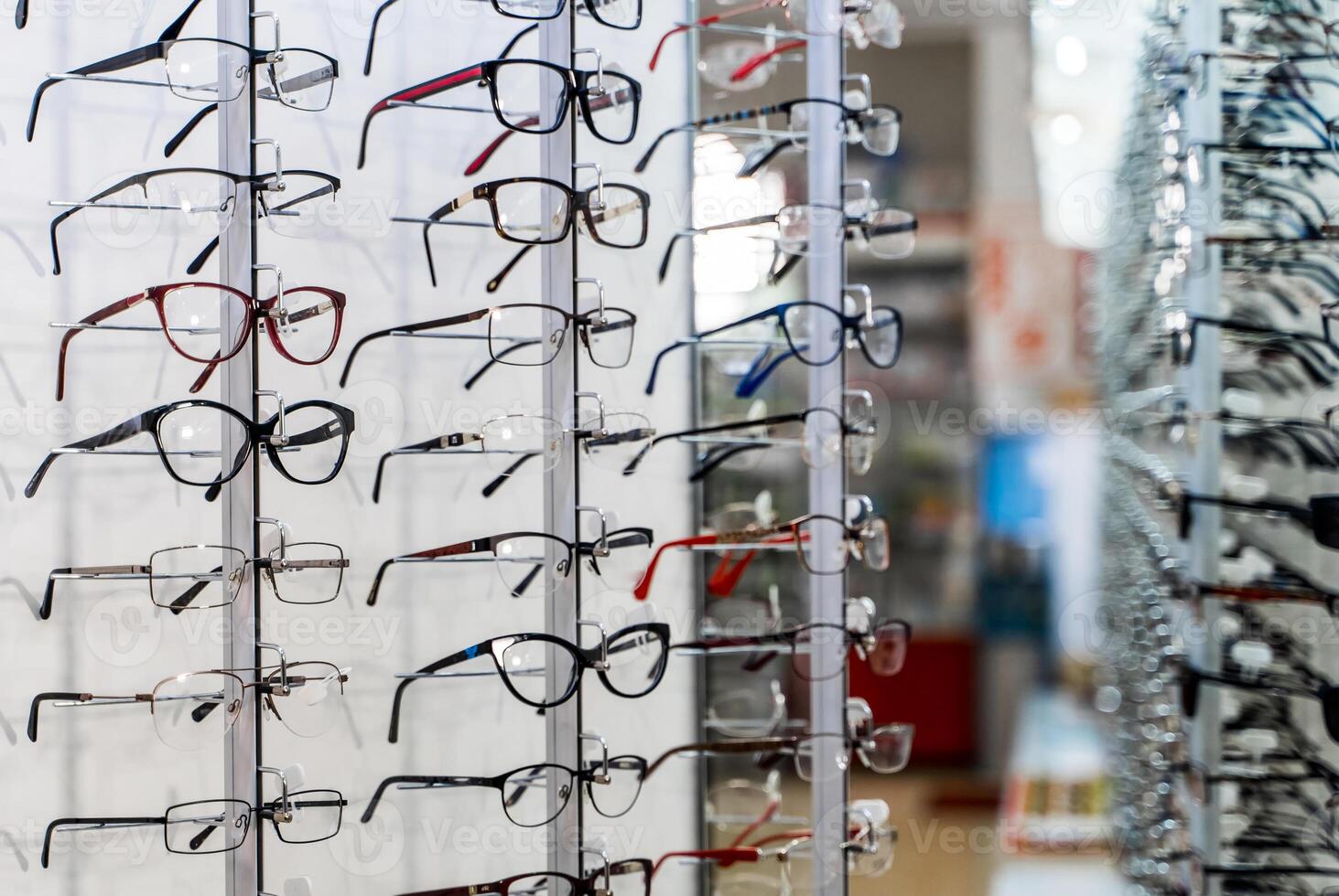 Row of glasses at an opticians. Eyeglasses shop. Stand with glasses in the store of optics. Showcase with spectacles in modern ophthalmic store. Closeup. photo