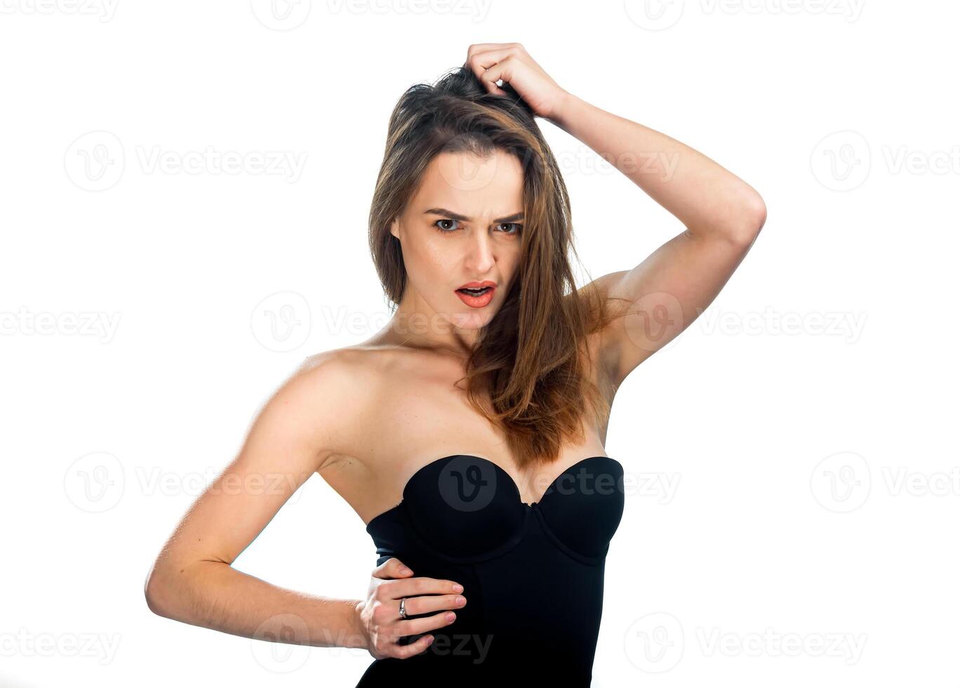 Pretty woman posing in black top over white background. Woman with long dark hair put hand over head. photo