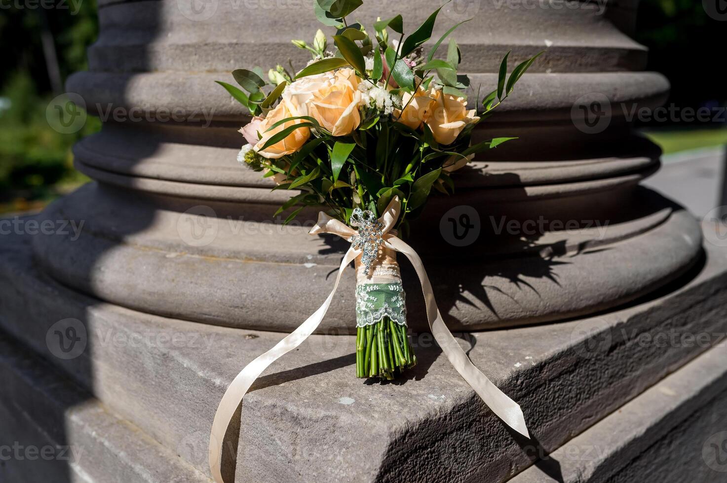 Wedding bouquet. Bride's flowers. Silk ribbons and yellow flowers. Dark grey column background. photo