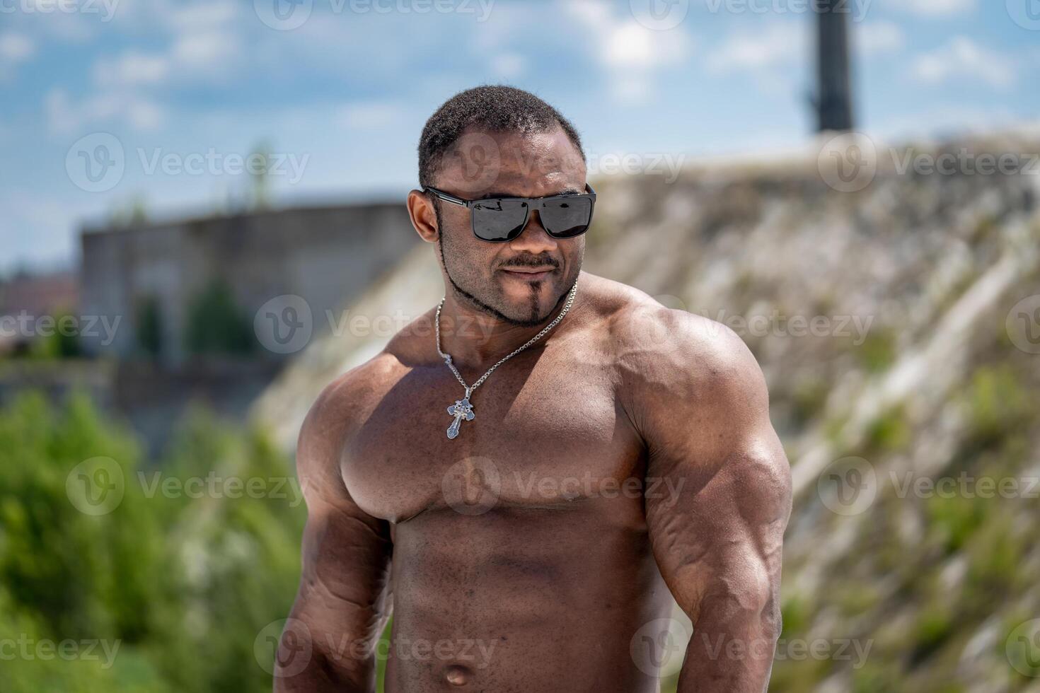 Shirtless muscular man outdoor in sunglasses. Young fit adult man with strong body. photo