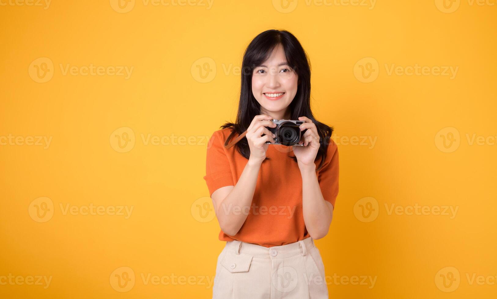 Excited asian woman traveler capturing her holiday memories with a camera and backpack. Adventure concept. photo