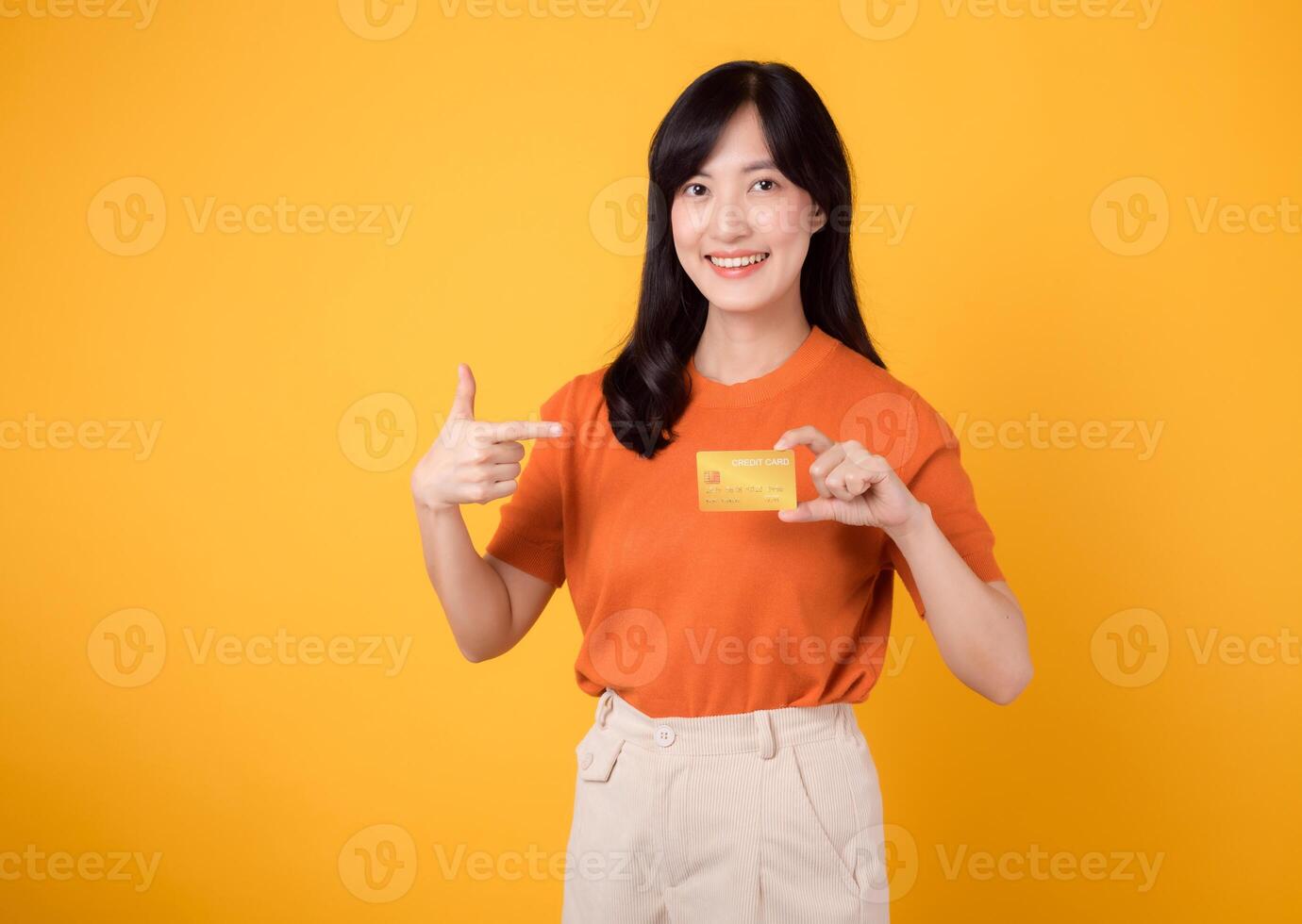 Confident young woman 30s showcasing a happy smile while holding a credit card, representing successful online shopping and secure payment transactions. photo