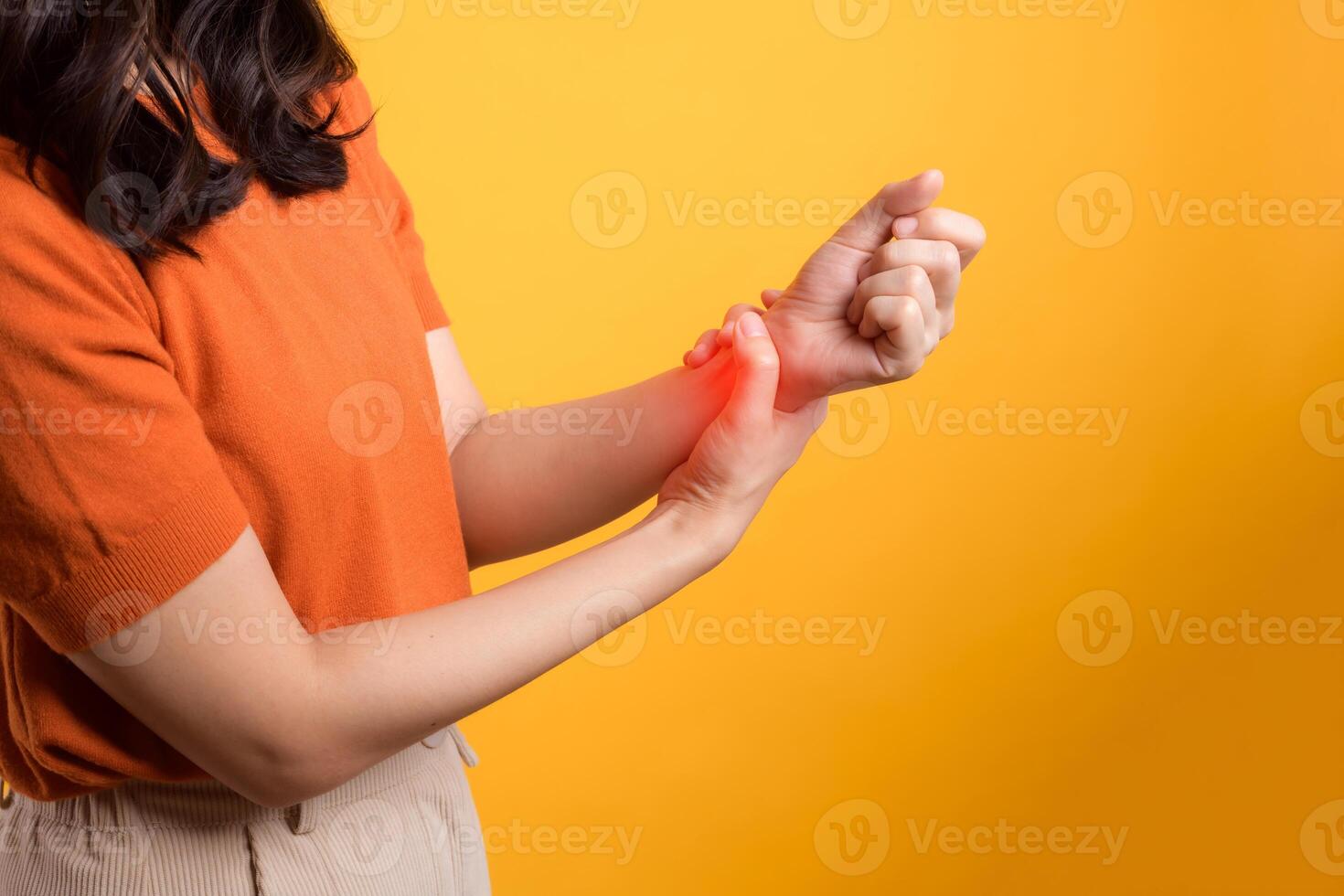 Studio portrait of a woman with wrist pain, portraying arthritis inflammation. Concept of health issue and discomfort. photo