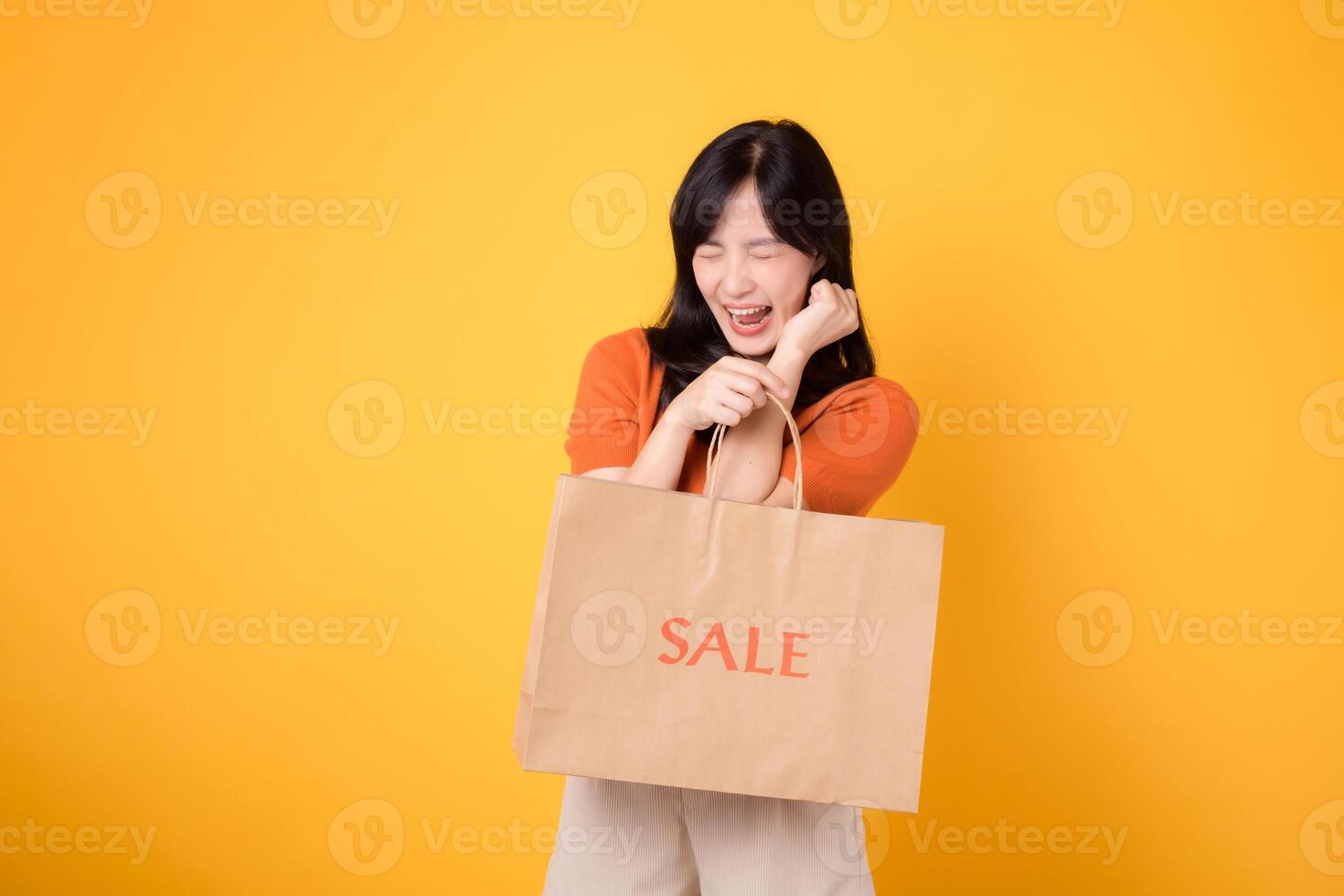 abrazo el sorpresa de imbatible ofertas mientras compras. contento joven mujer vitrinas su compras, reflejando el alegría de descubriendo emocionante gangas. aislado en amarillo antecedentes. foto