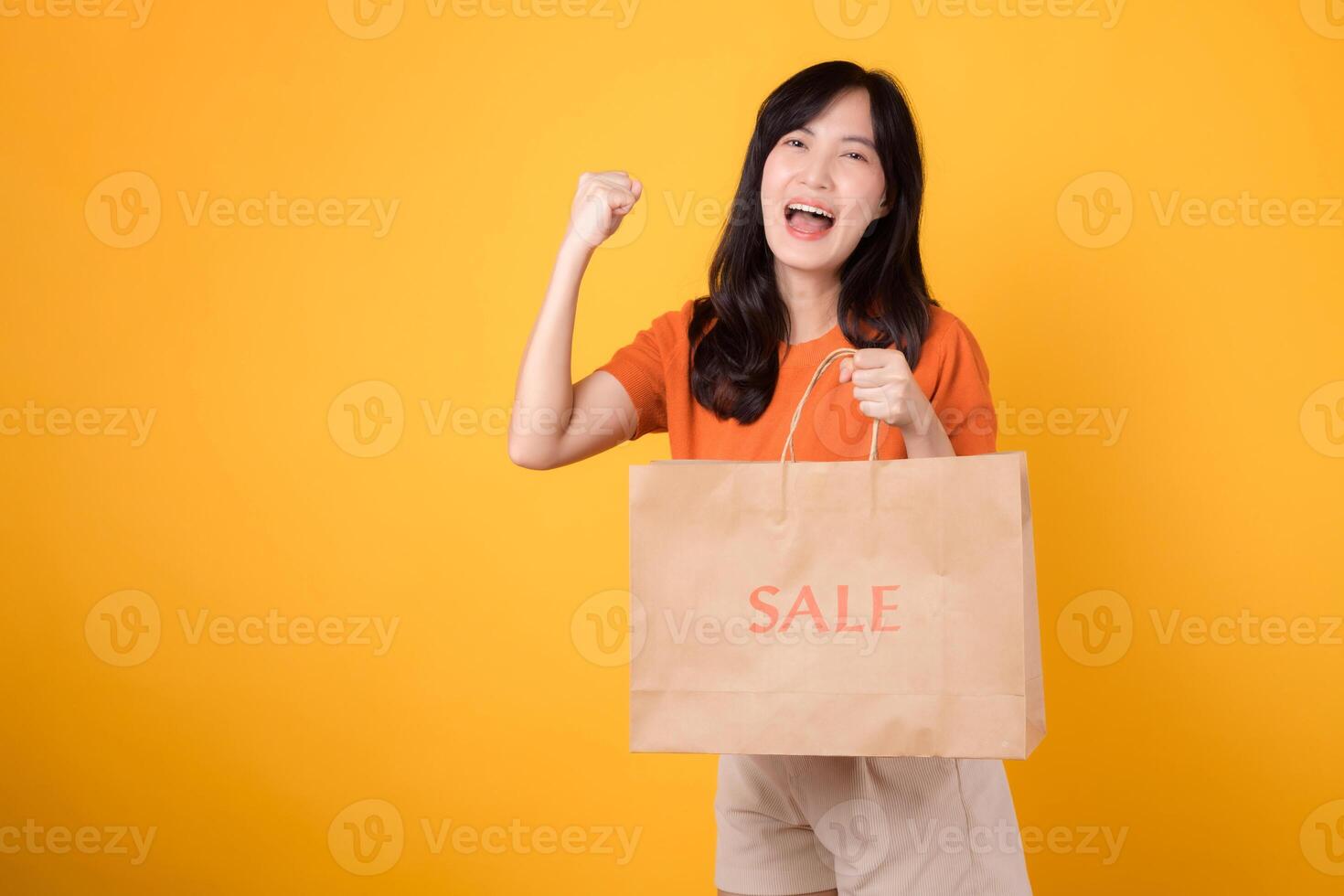 unirse el celebracion de amor y increíble ofertas para alegre compras experiencia. de moda asiático mujer revela su compras, encarnando el emoción de inteligente compras. aislado en amarillo antecedentes. foto