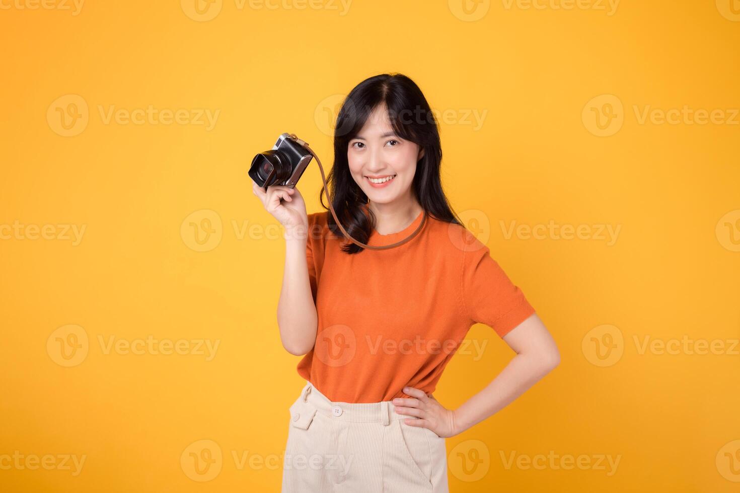 Happy adult tourist holding camera, ready for a colorful vacation journey. Exciting travel plans in motion. photo