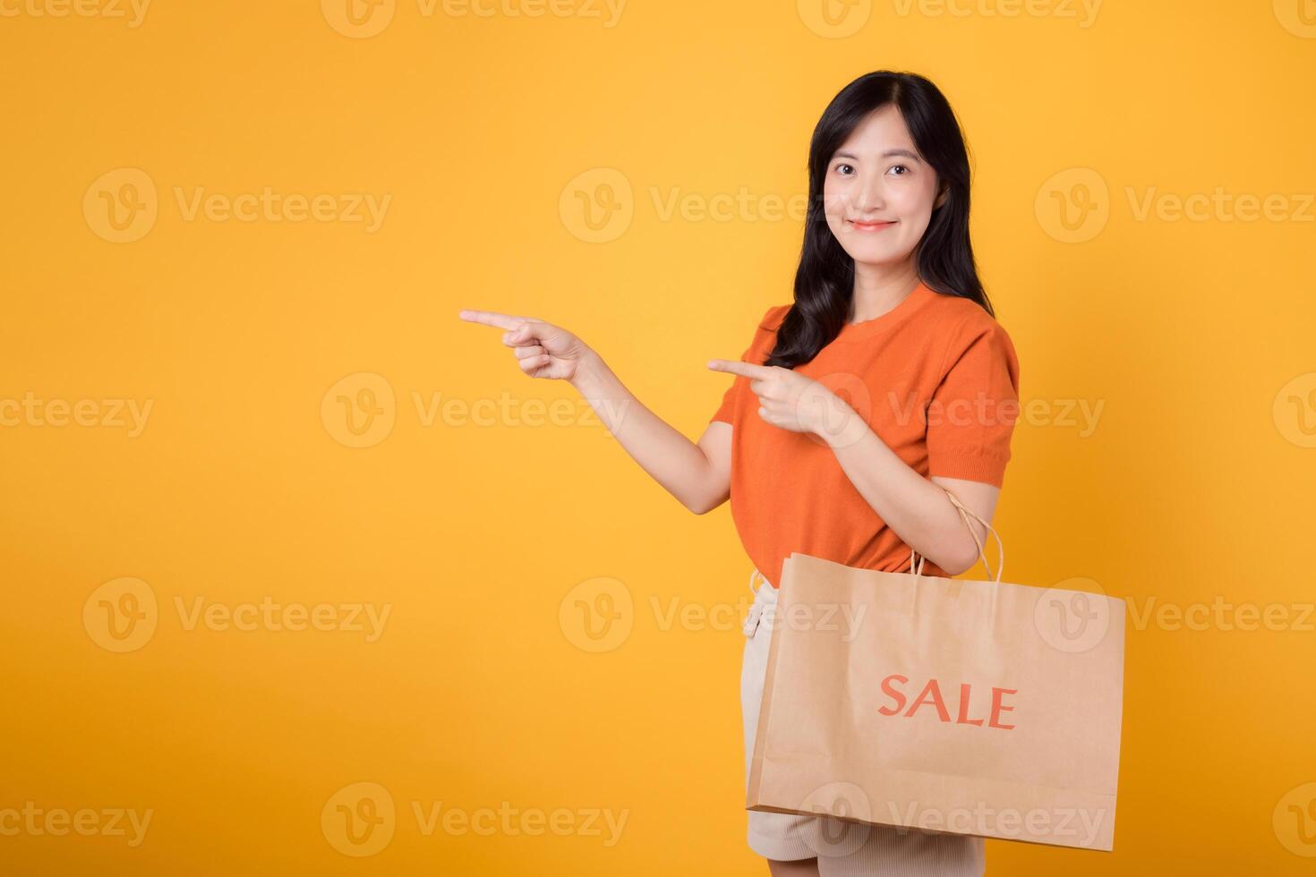 contento joven comprador celebra el emoción de descuentos, señalando a gratis Copiar espacio mientras participación compras pantalones con un alegre gesto. foto