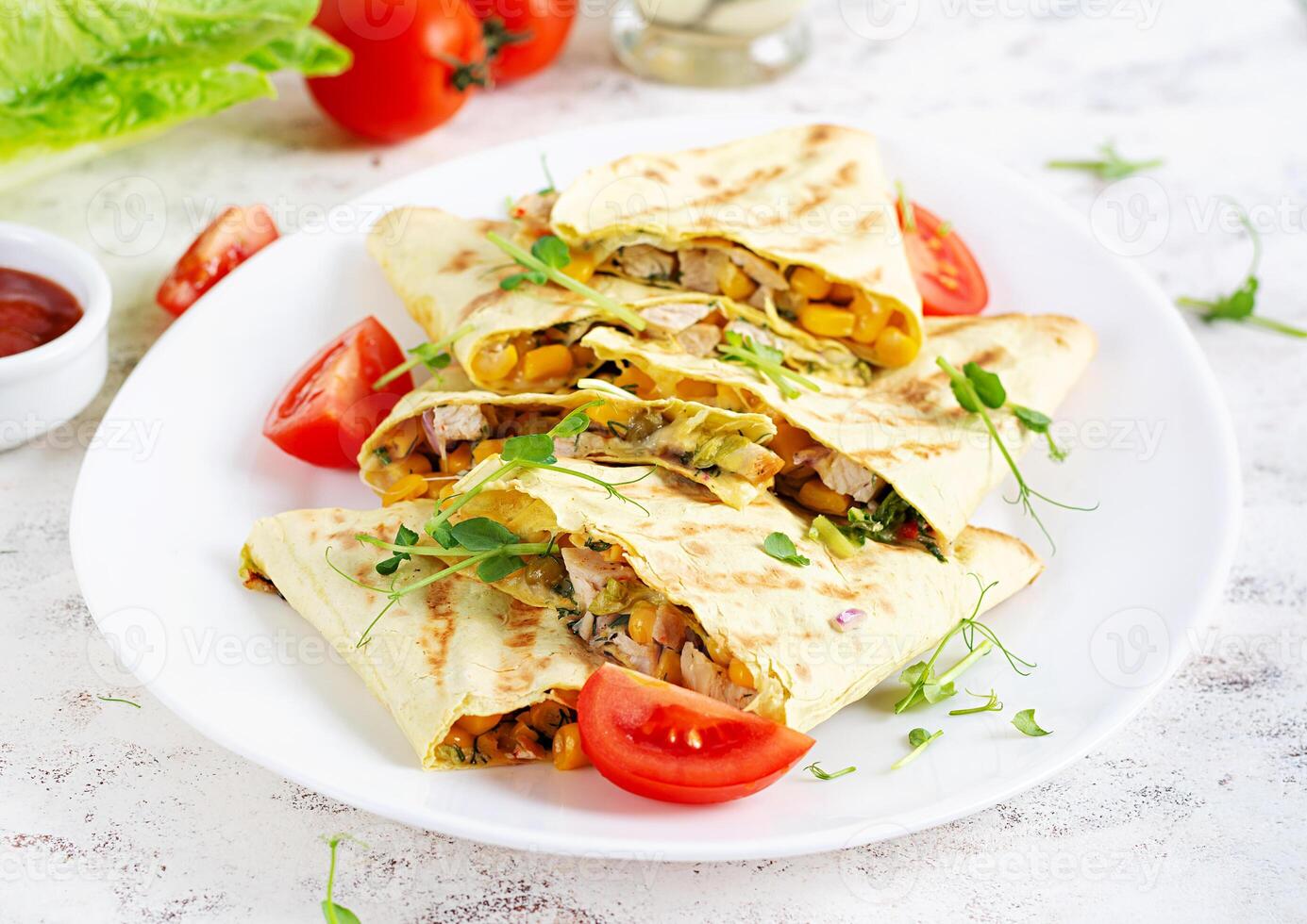 Mexican Quesadilla wrap with chicken, corn and sweet pepper on white plate. photo