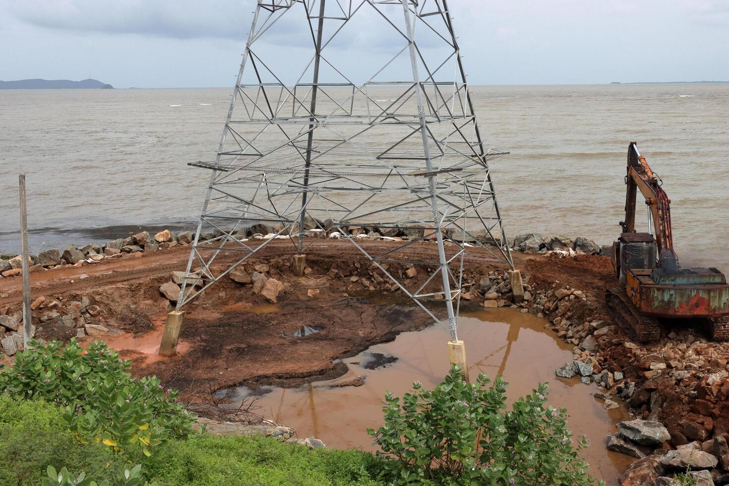 un excavador hace un montículo de arena en el costa. proteccion de el playa zona para el invierno desde inundación. industrial construcción equipo y maquinaria foto