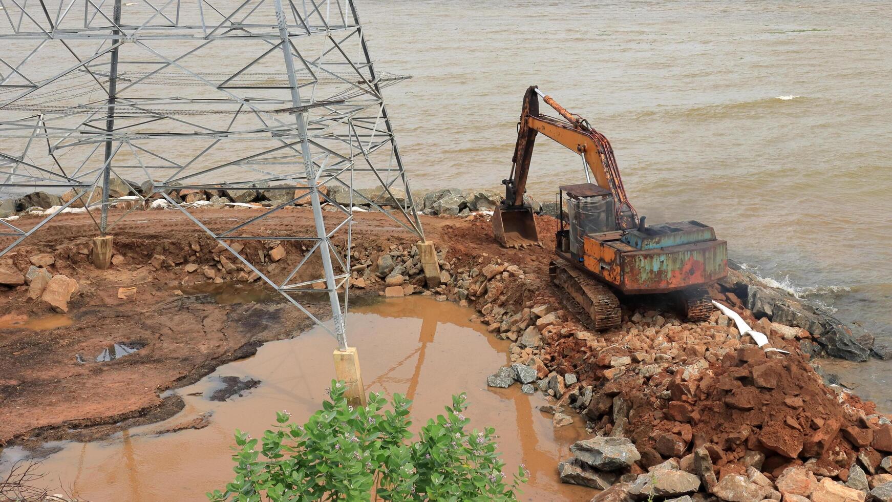 An excavator makes a mound of sand on the seashore.  Protection of the beach area for the winter from flooding. Industrial construction equipment and machinery photo