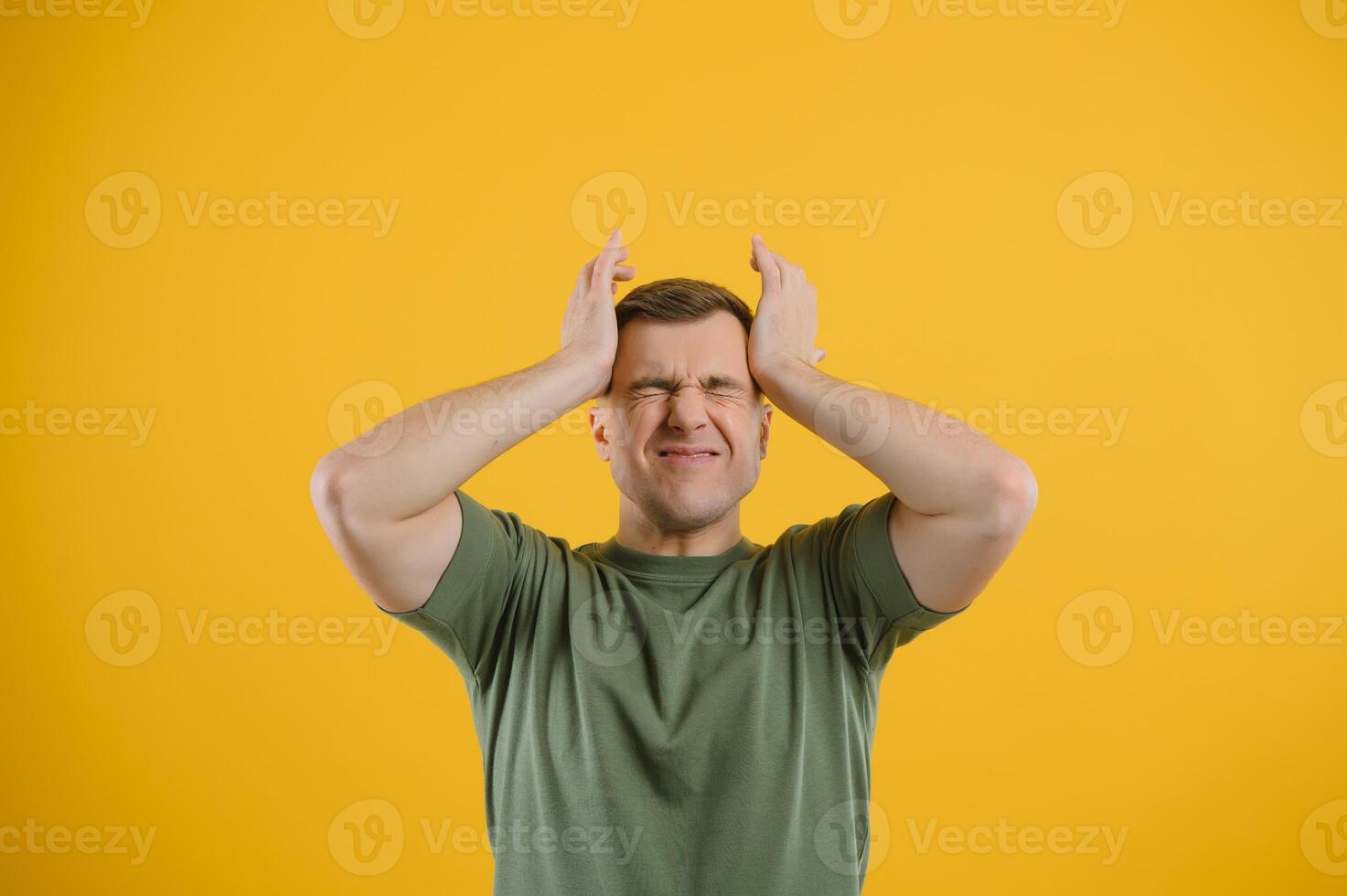 Portrait of a young man holding his head with his hands. Concept of despair and hopelessness. Frustration. Migraine photo