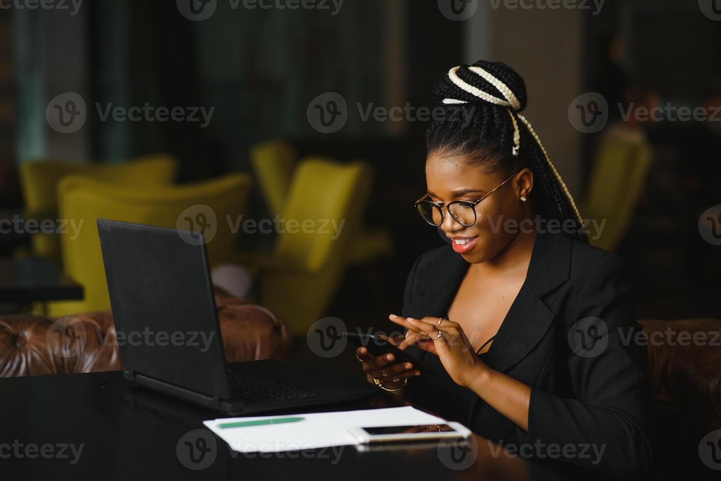 Young beautiful Afro-American businesswoman smart phone and smiling while working in cafe photo