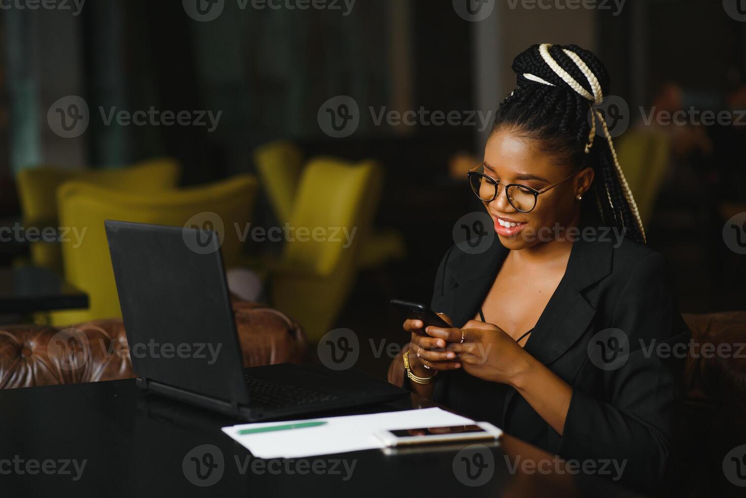 Young beautiful Afro-American businesswoman smart phone and smiling while working in cafe photo