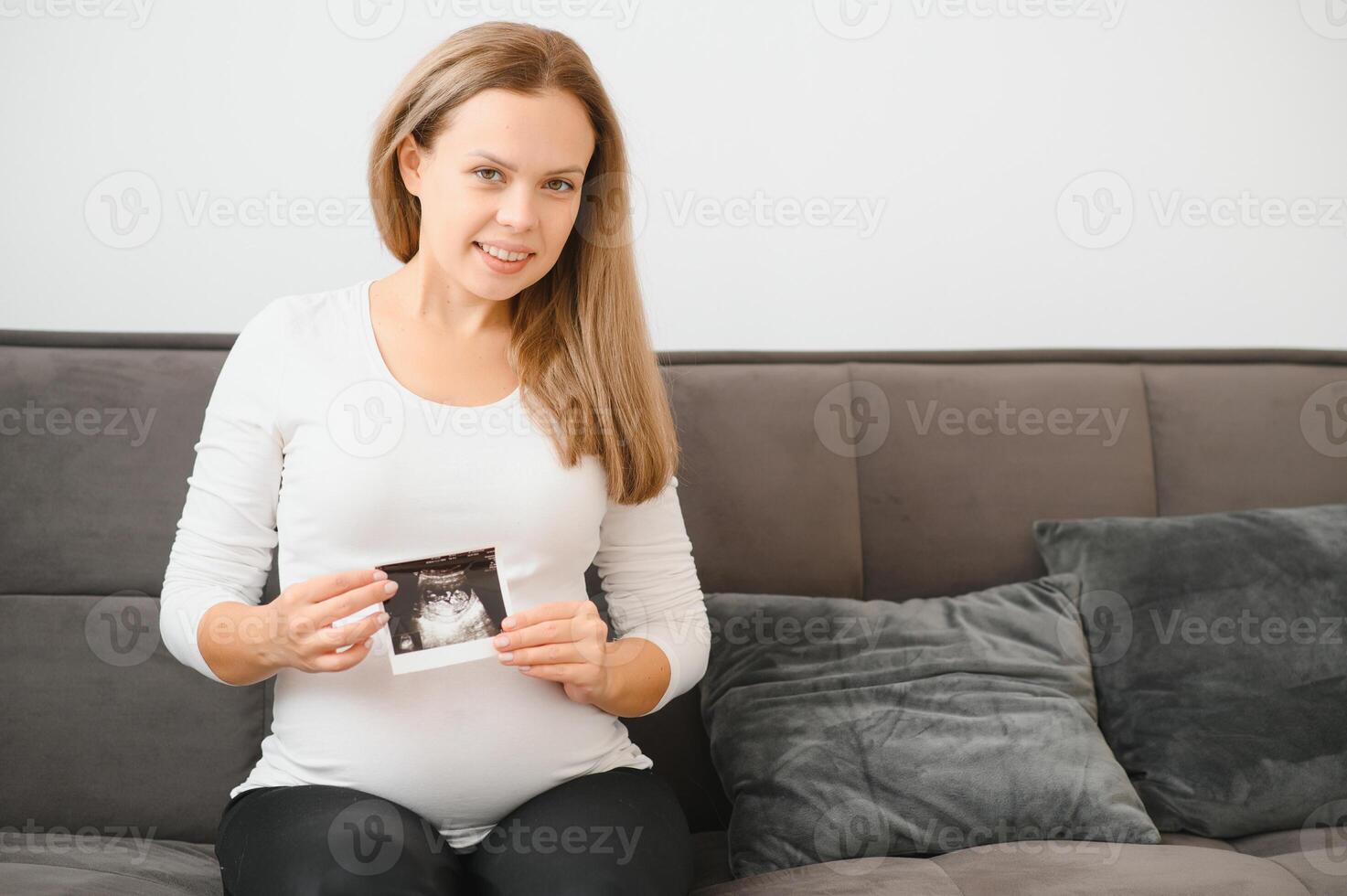 Pregnant women holding echo pictures in hand photo