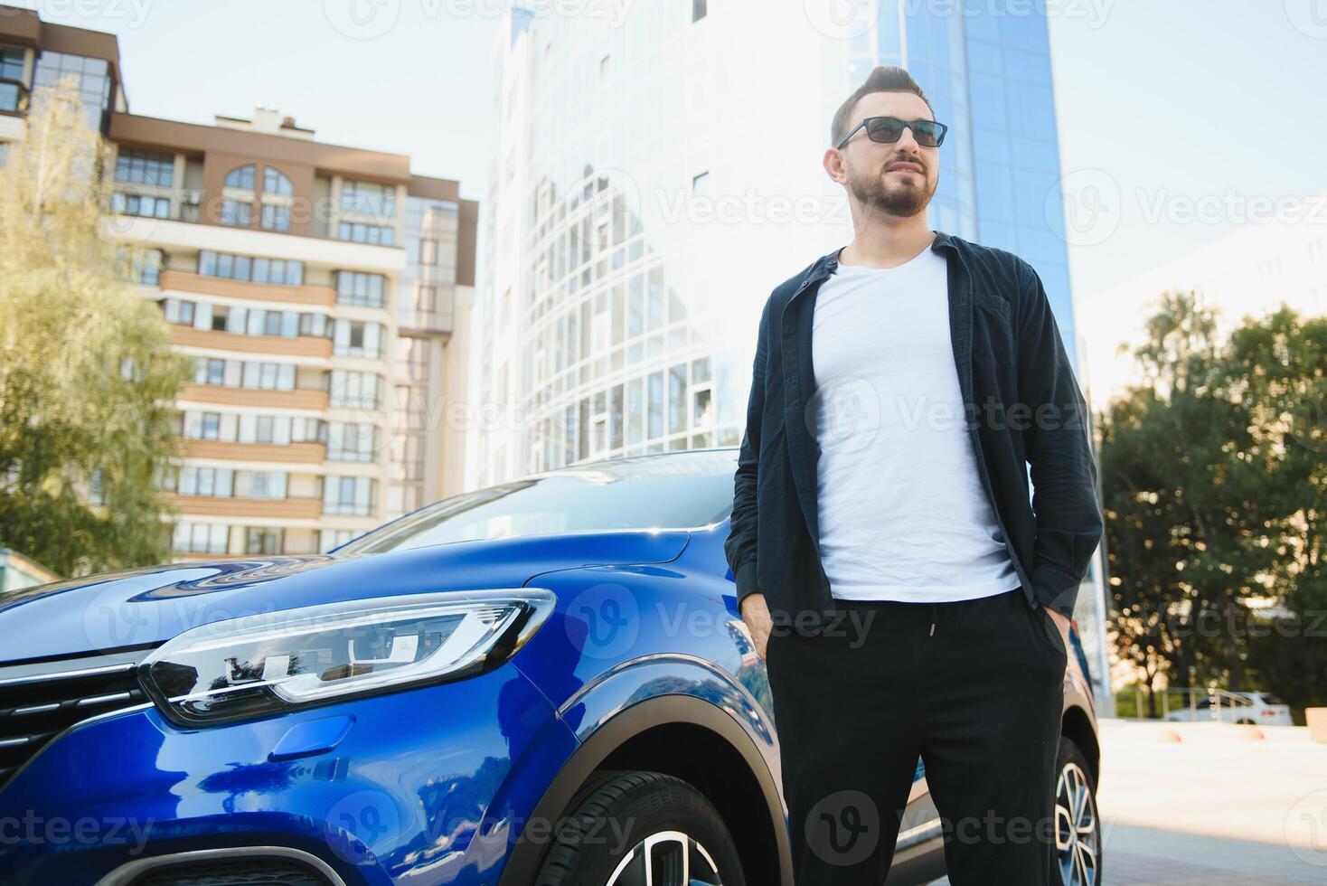 Handsome young man in standing near car outdoors photo