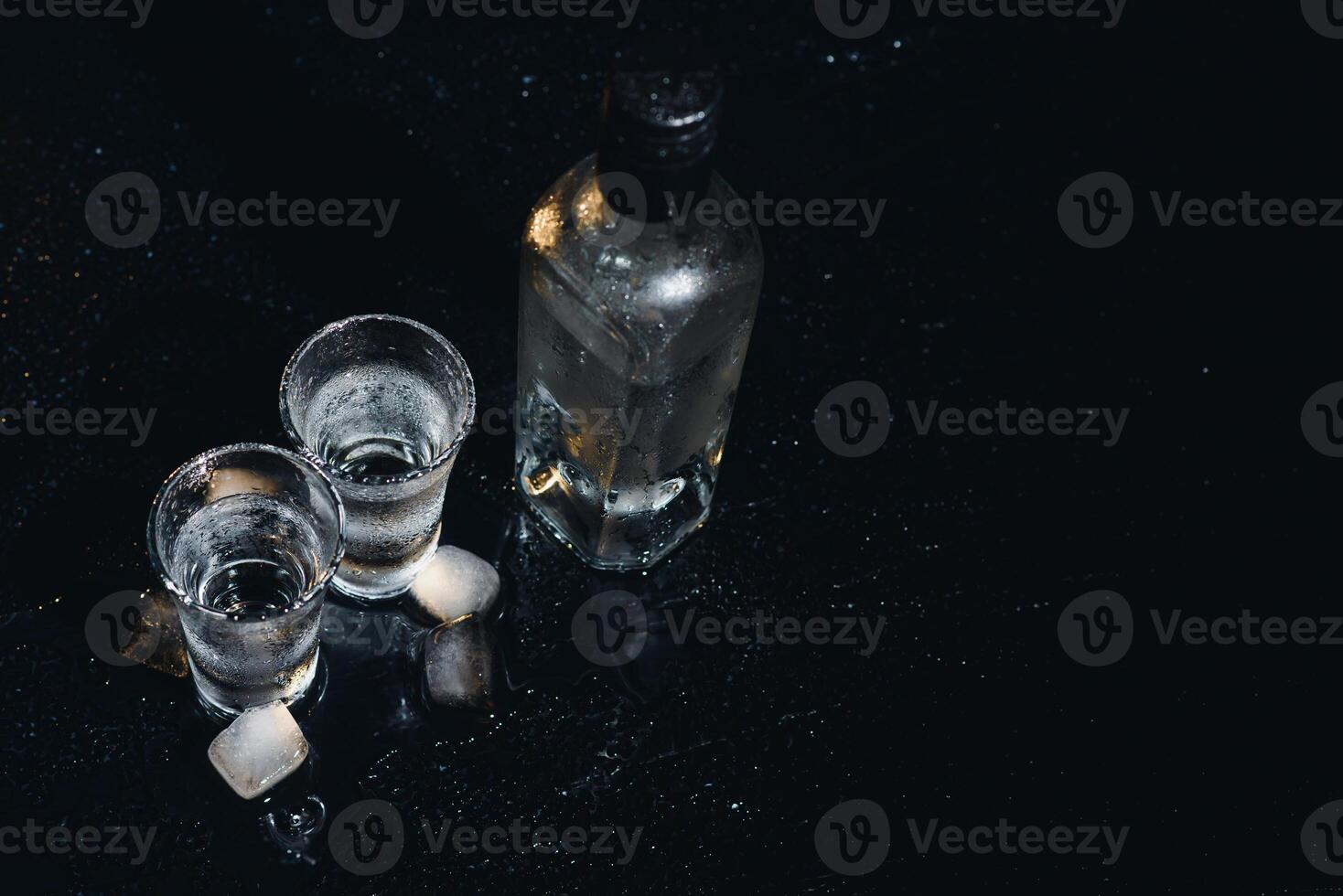 Vodka. Shots, glasses with vodka with ice .Dark background. Copy space .Selective focus. photo