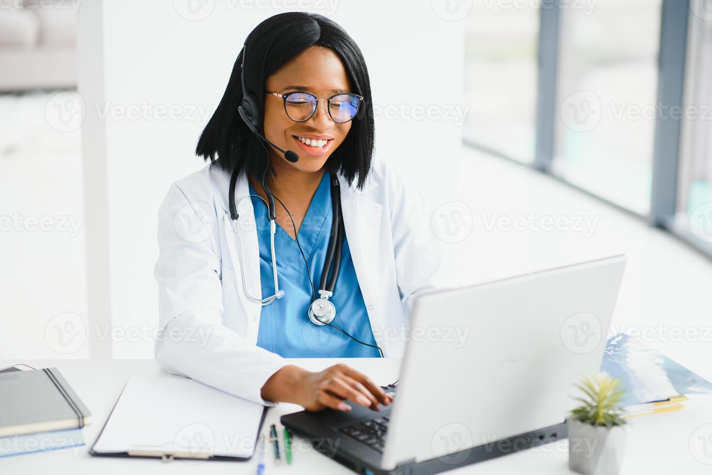 Young African-American doctor working on laptop in clinic. photo