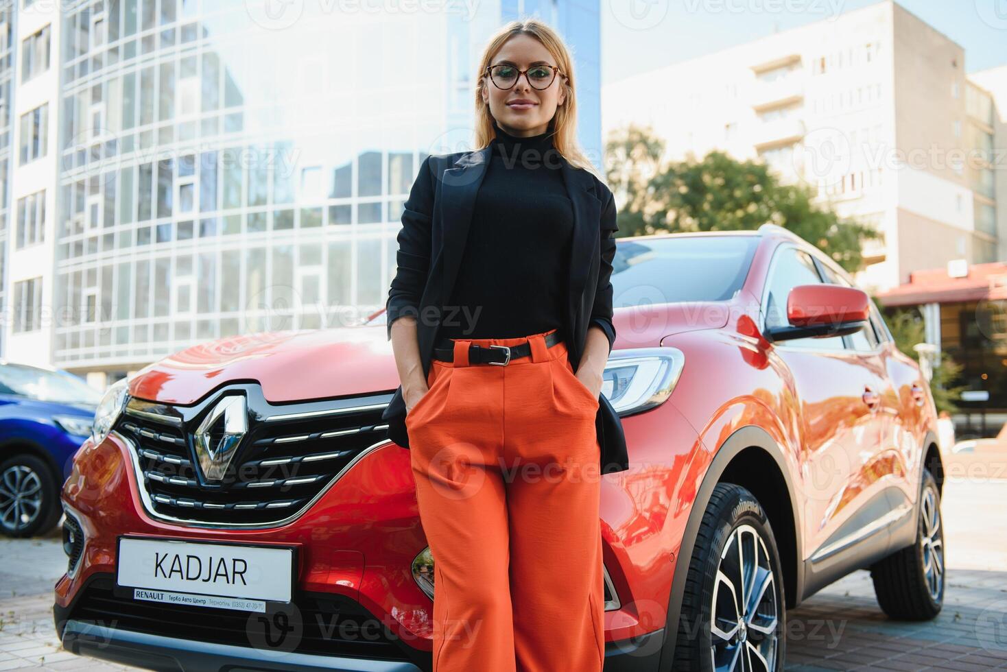 Professional female manager standing near car at office building photo