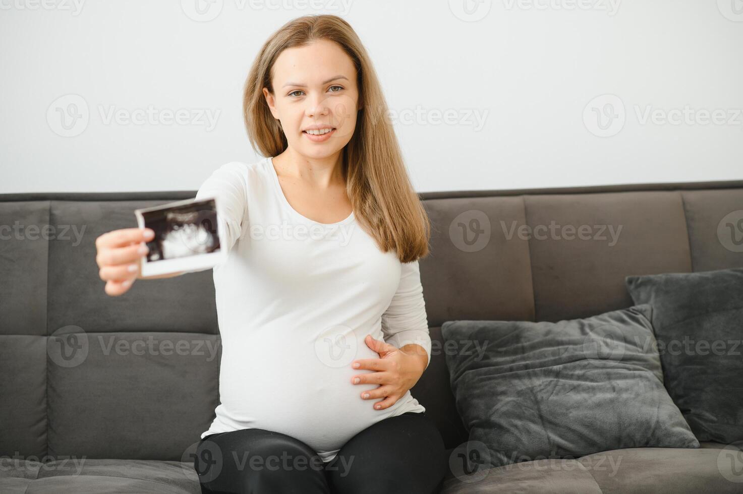 Pregnant women holding echo pictures in hand photo