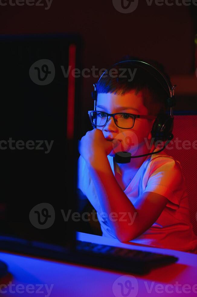 Boy in the headphones is playing a game. photo