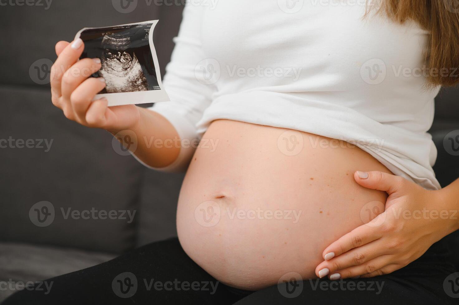 Pregnant woman hands holding ultrasound photo