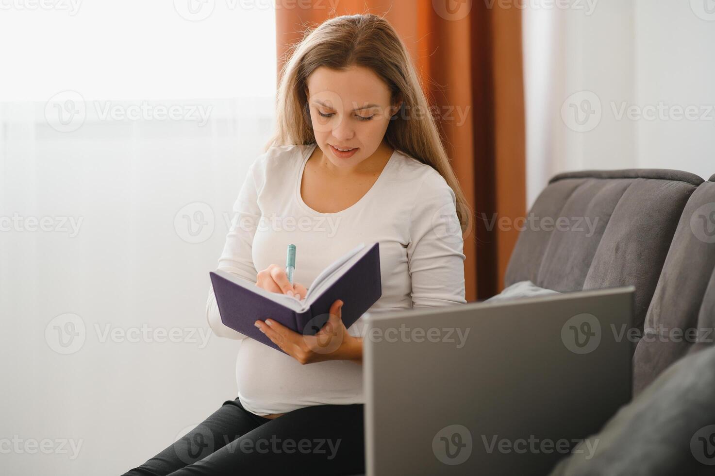 Pregnant woman video chatting with doctor on laptop. Professional medical online consultation concept. photo