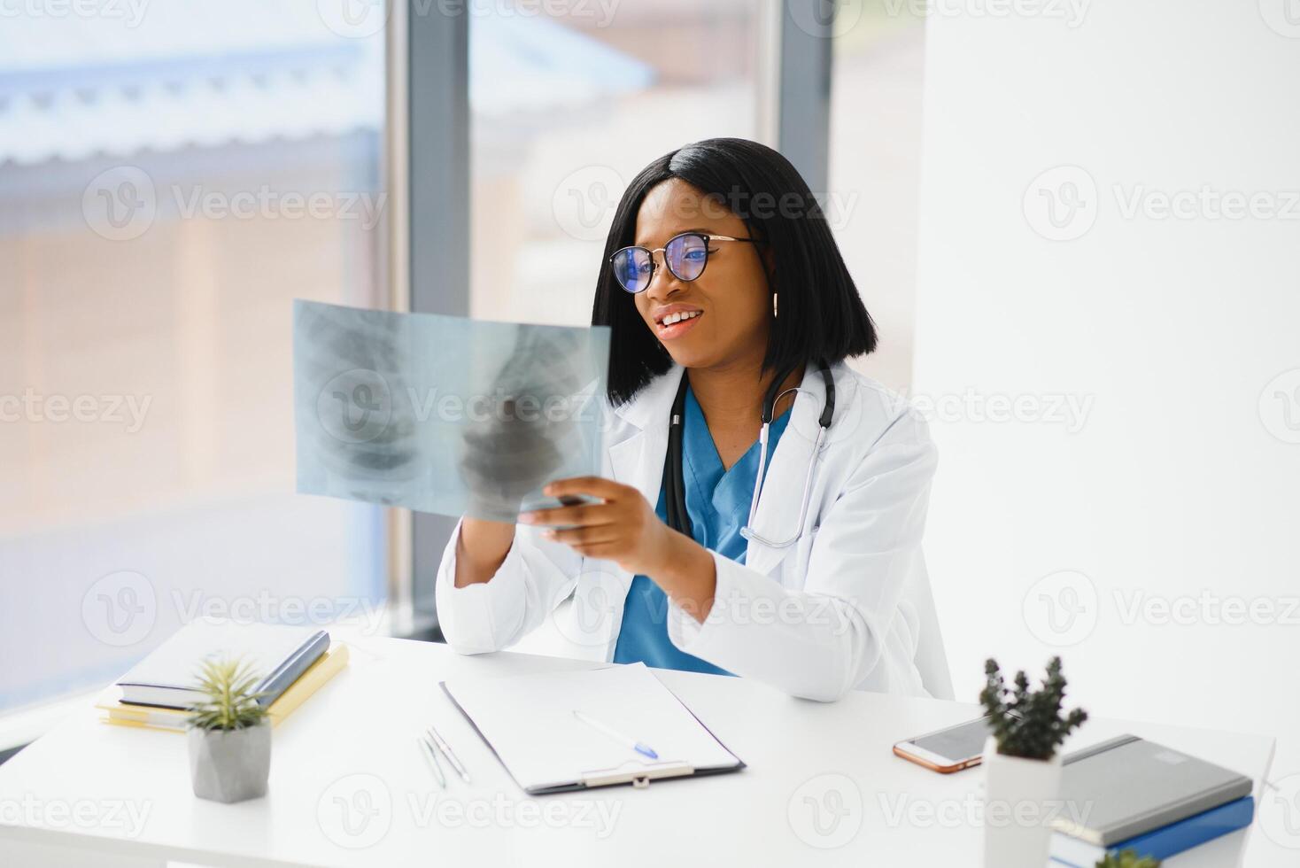 beautiful female african medical worker holding x-ray. photo