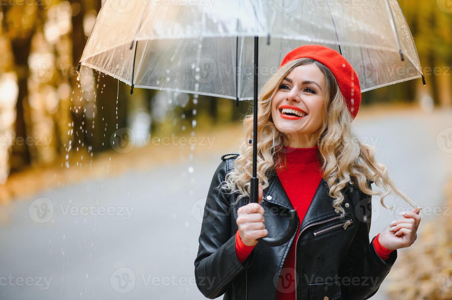 woman with umbrella walking at the rain in beautiful autumn park. photo