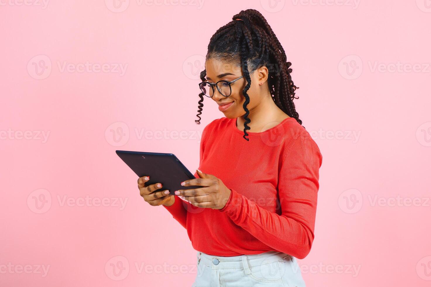 Portrait of her she nice-looking attractive lovely charming pretty cheerful cheery wavy-haired girl holding in hands tablet working remotely isolated over pink pastel color background photo