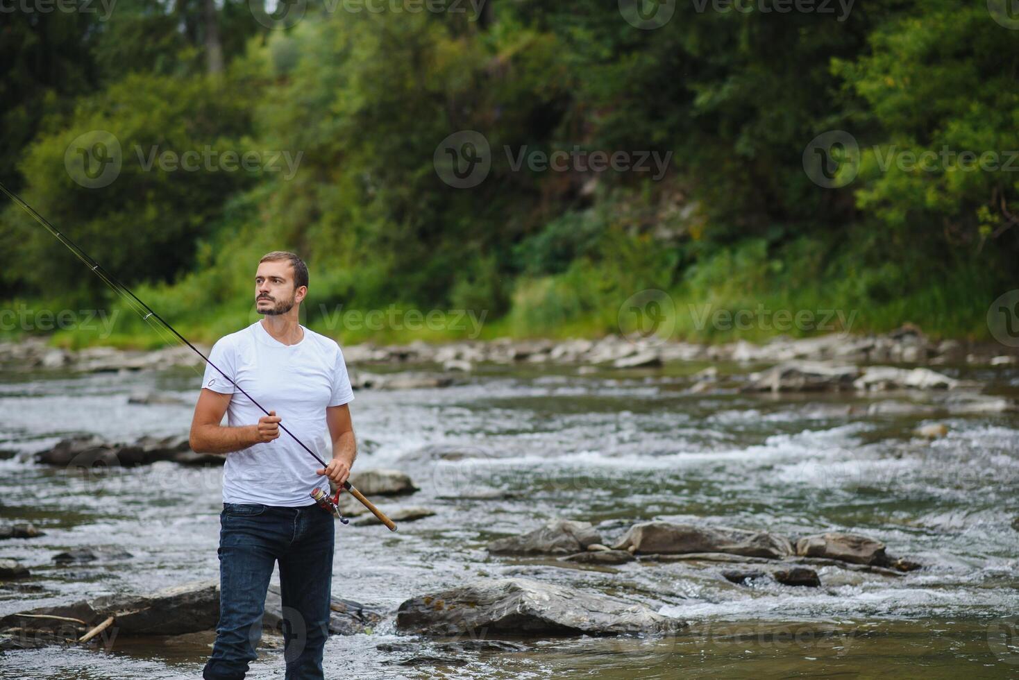 Bearded man catching fish. Summer leisure. Mature man fishing on the pond. Portrait of cheerful senior man fishing. Male fishing. Fishman crocheted spin into the river waiting big fish photo