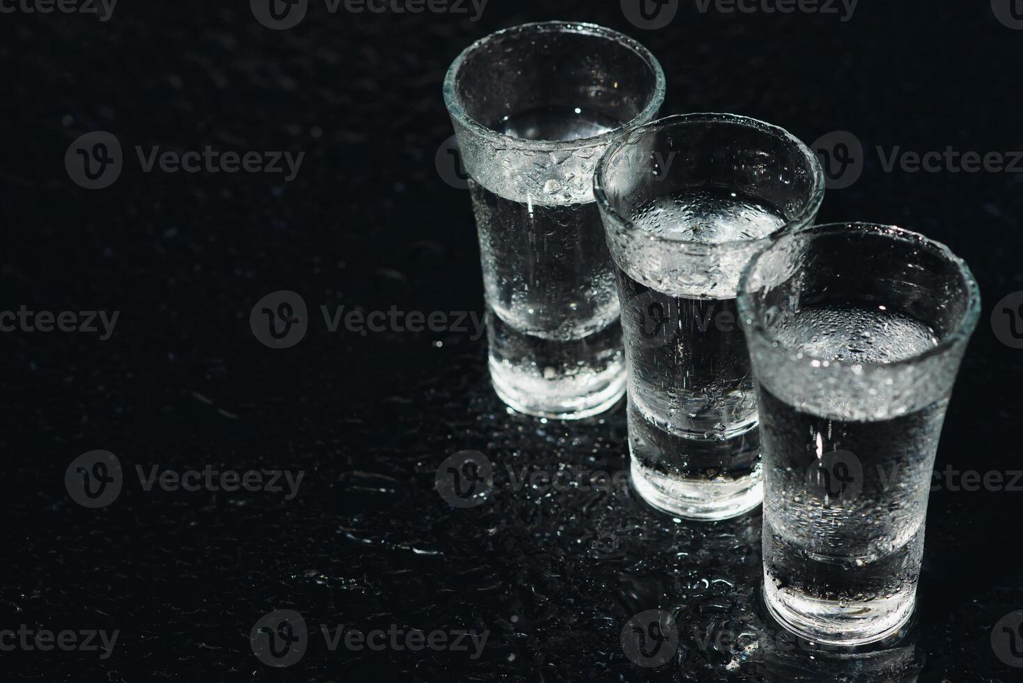Vodka. Shots, glasses with vodka with ice .Dark background. Copy space .Selective focus. photo