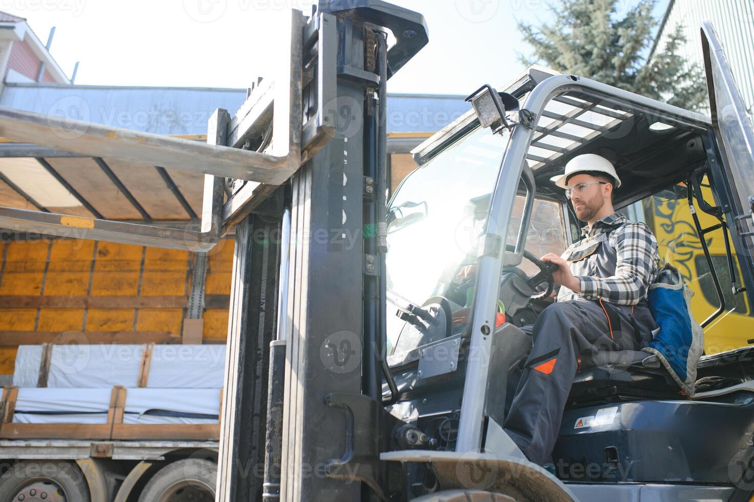 A man on a forklift works in a large warehouse, unloads bags of raw materials photo