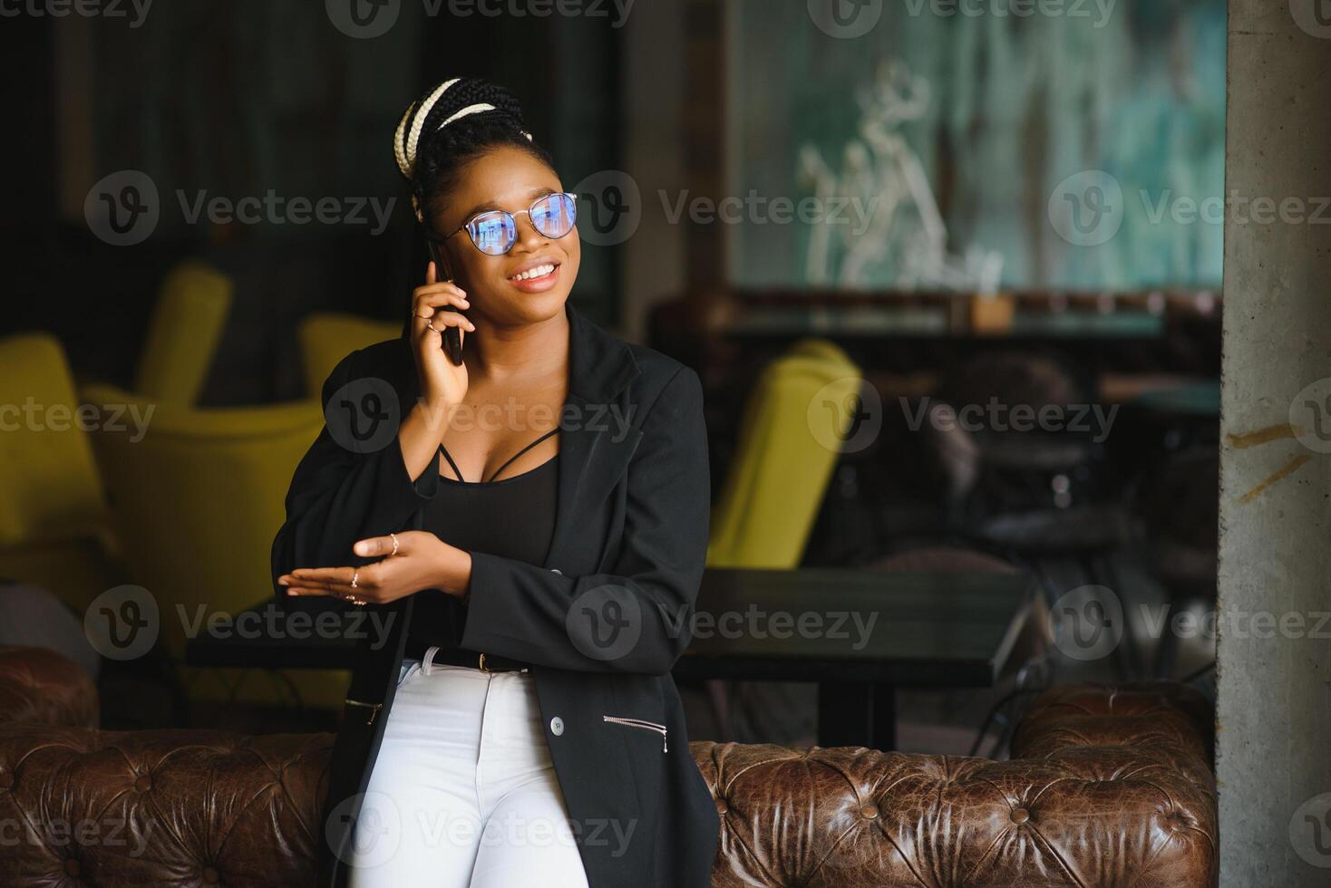 Young beautiful Afro-American businesswoman smart phone and smiling while working in cafe photo