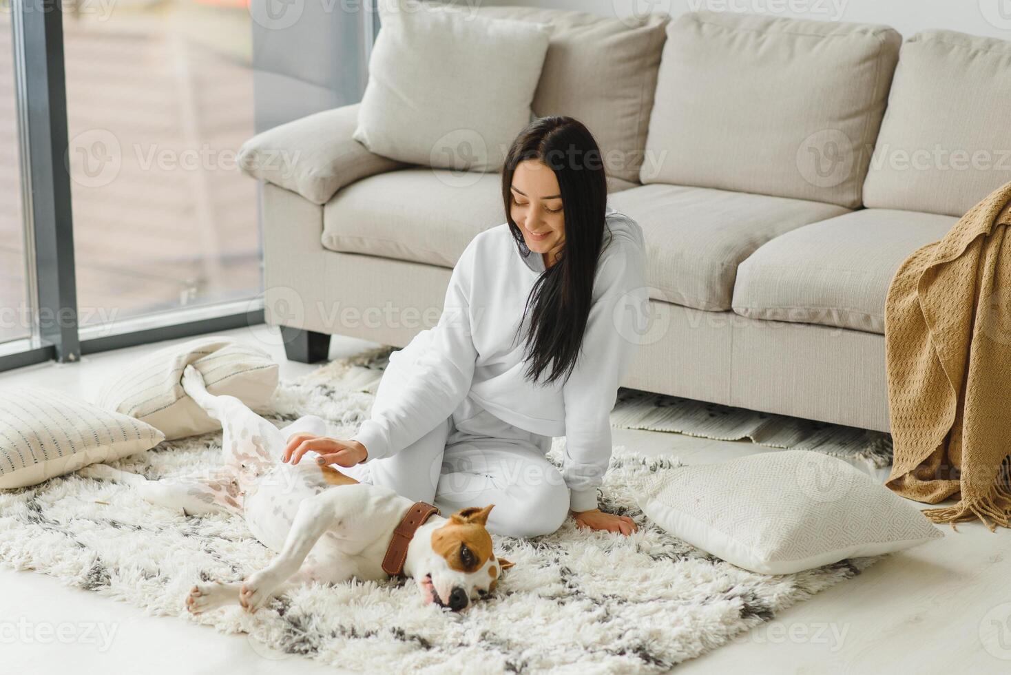 Young woman with her cute dog at home. Lovely pet. photo