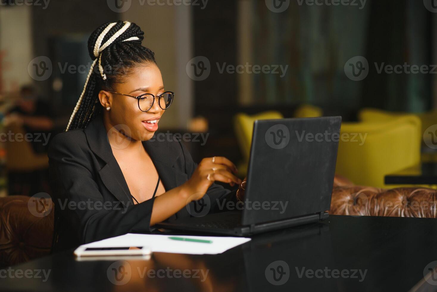 Young beautiful Afro-American businesswoman smart phone and smiling while working in cafe photo