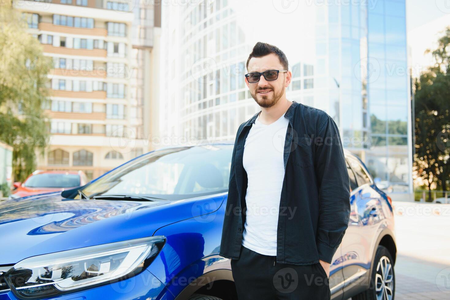 Handsome young man in standing near car outdoors photo