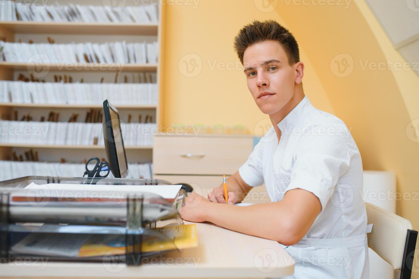 Portrait of young male technician operating ultrasound machine photo