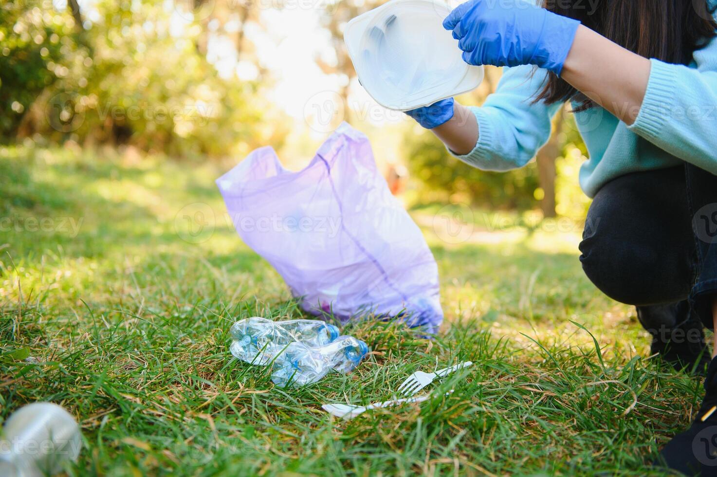 Young man collects garbage in a bag, volunteering photo