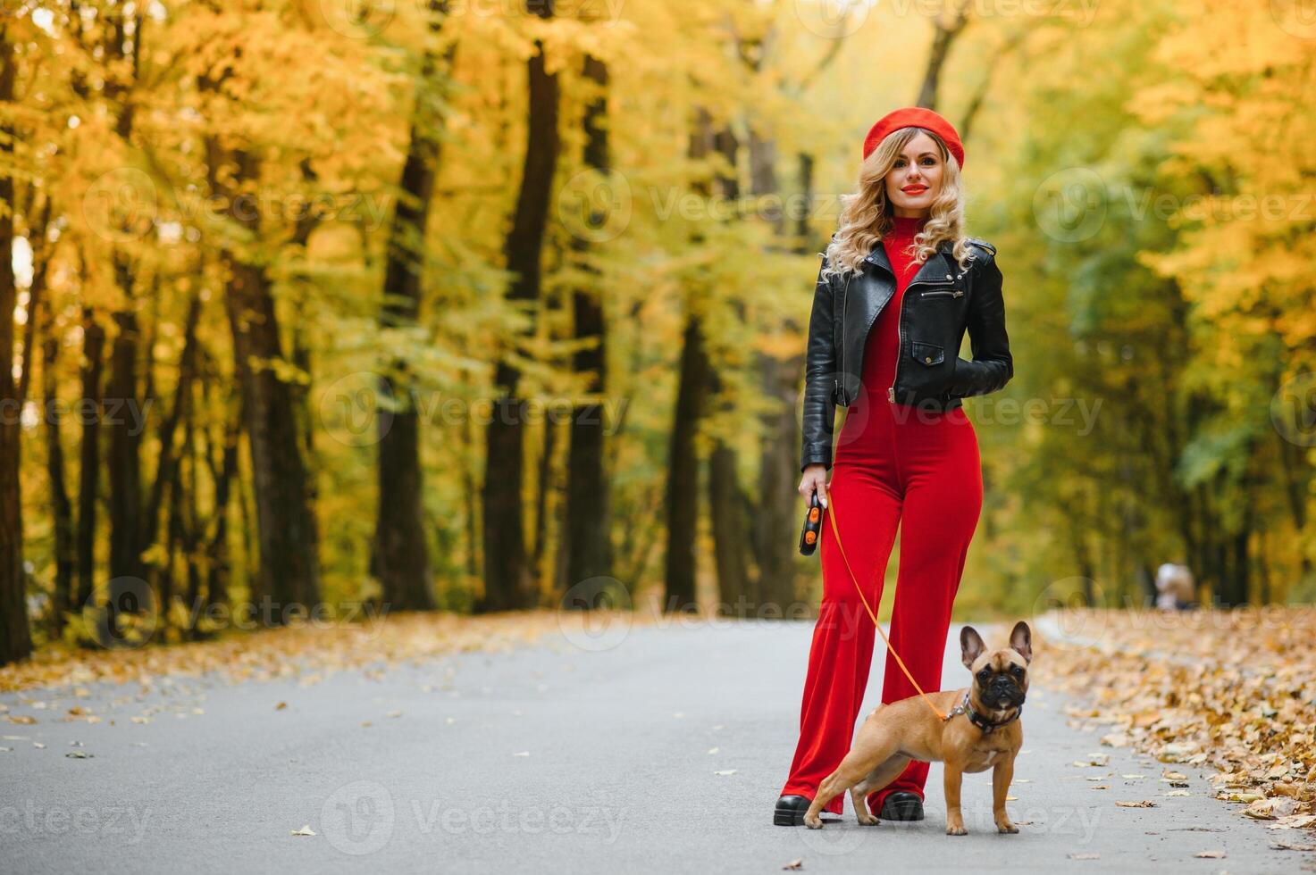 Beautiful and happy woman enjoying in park walking with her adorable French bulldog. photo