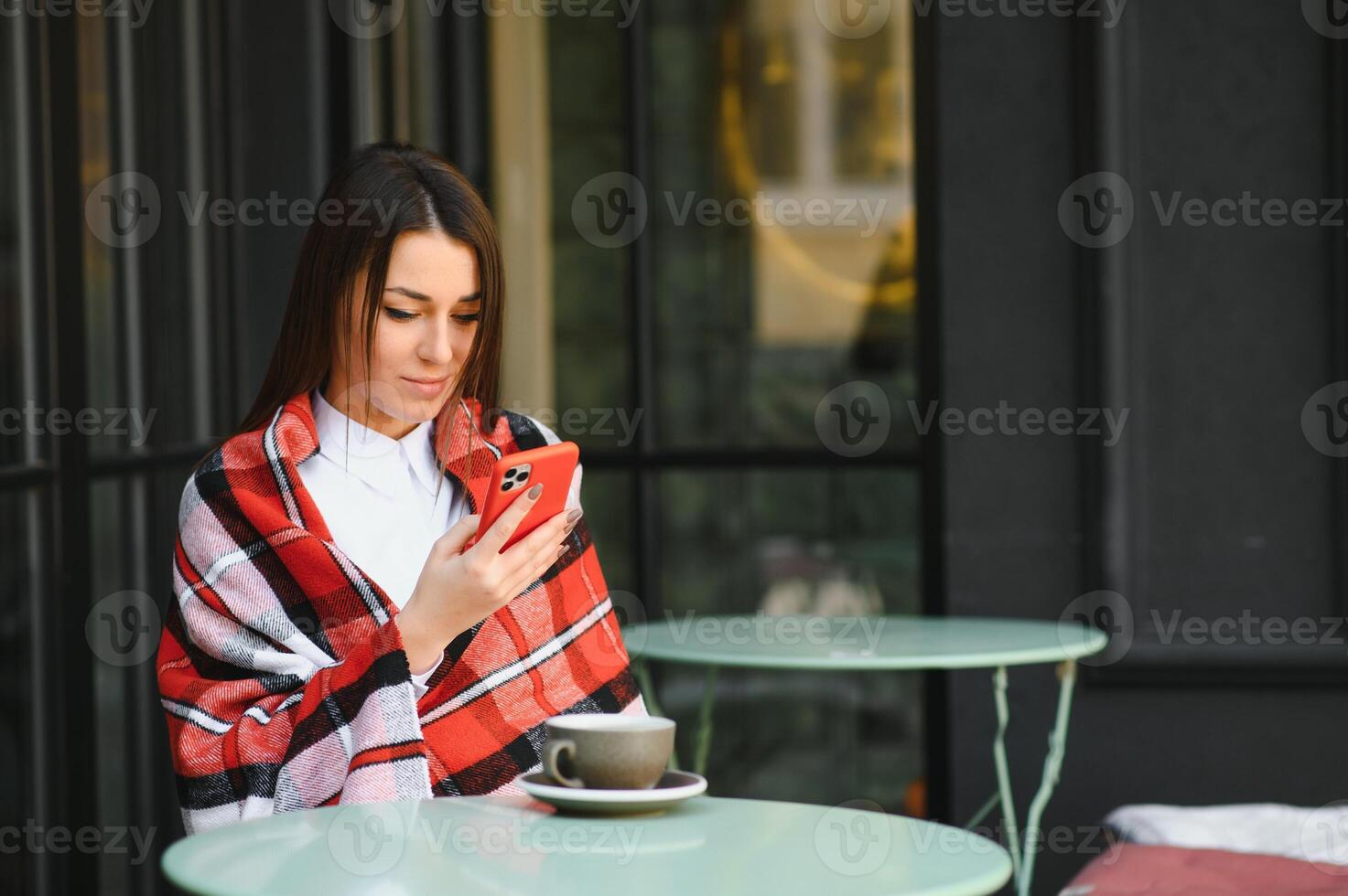 retrato de una joven hermosa mujer sentada en un café al aire libre bebiendo café foto