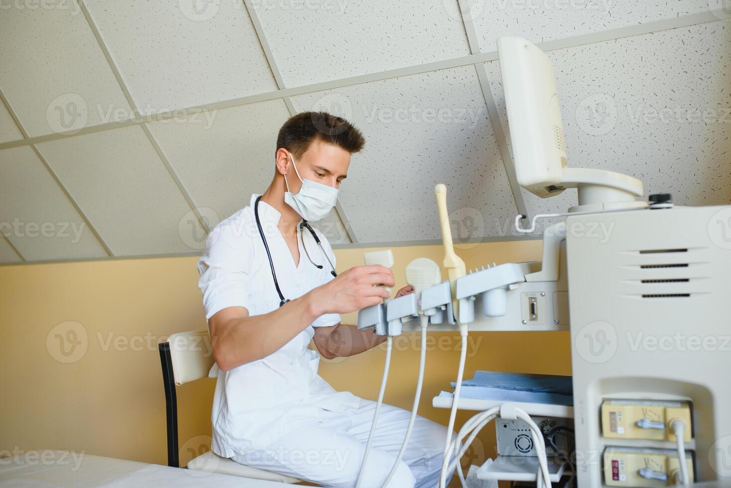 Sonographer operating modern ultrasound machine in clinic photo