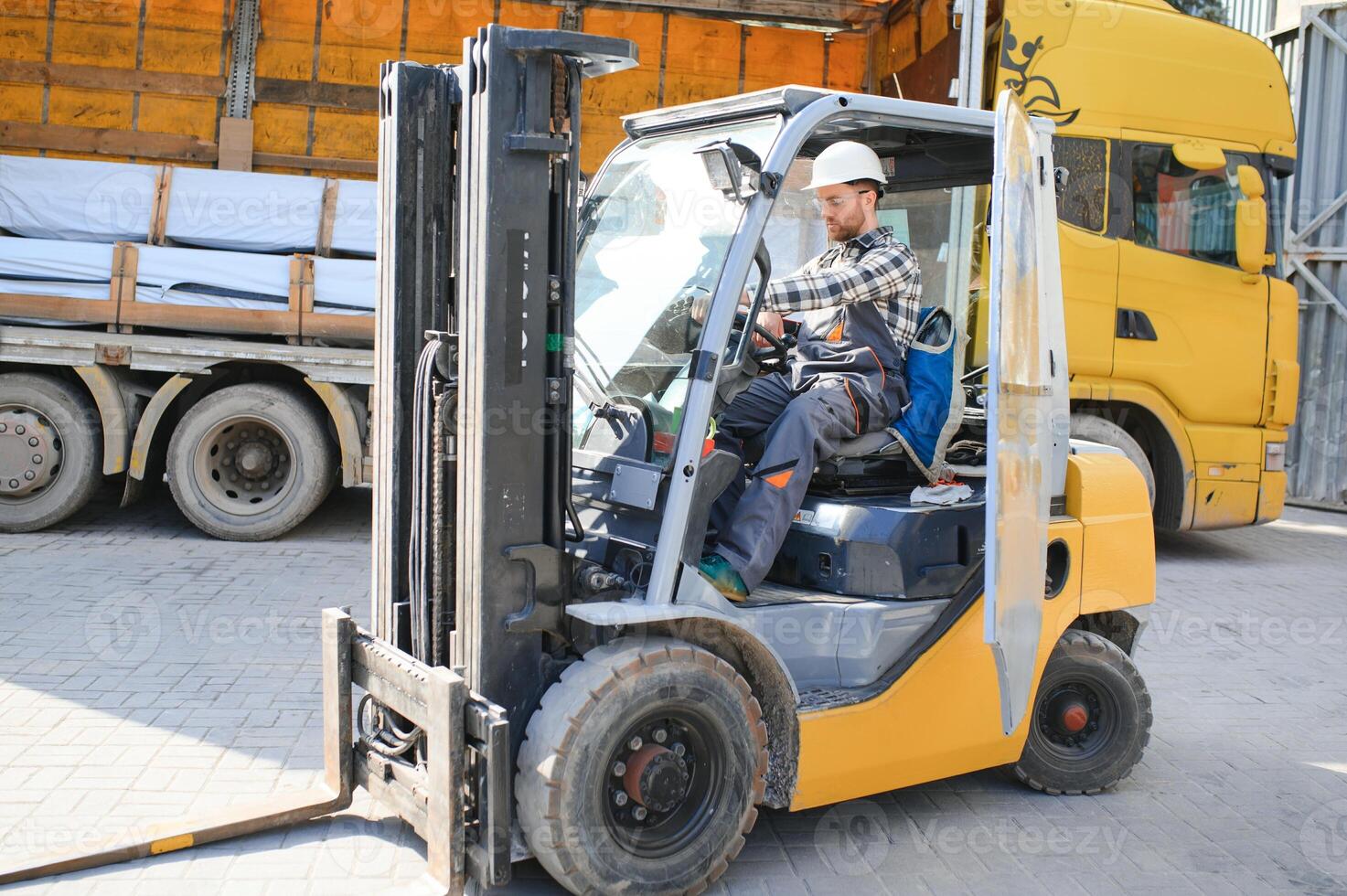 Portrait of professional forklift driver in factory's warehouse photo