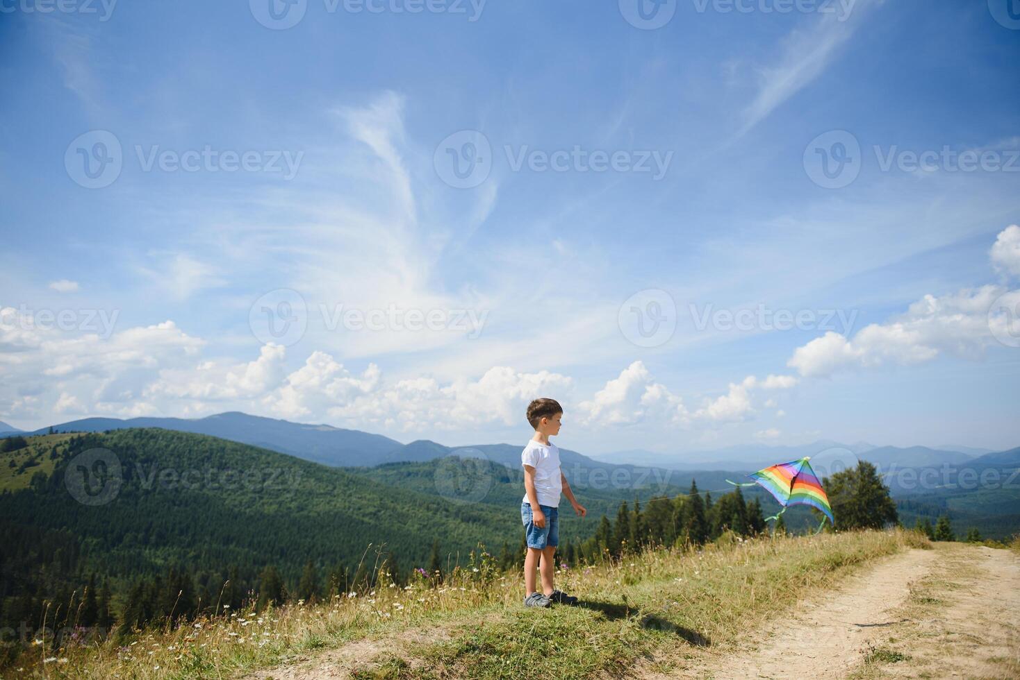 Young boy flies his kite in an open field. a pictorial analogy for aspirations and aiming high photo