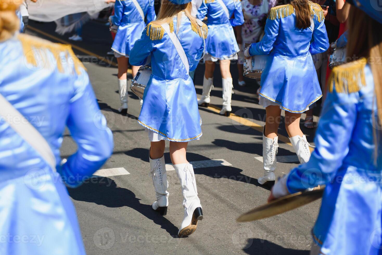 majorettes with white and blue uniforms perform in the streets of the city. photographic series photo