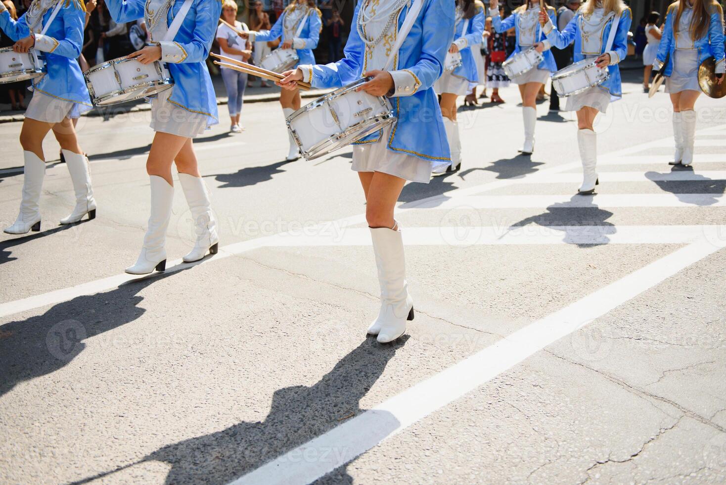 majorettes with white and blue uniforms perform in the streets of the city. photographic series photo