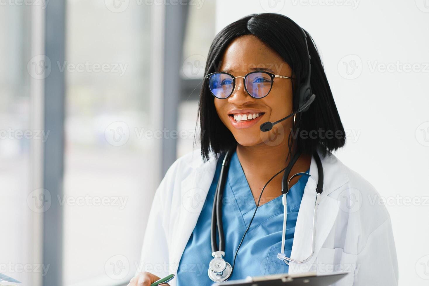 Young African-American doctor working on laptop in clinic. photo