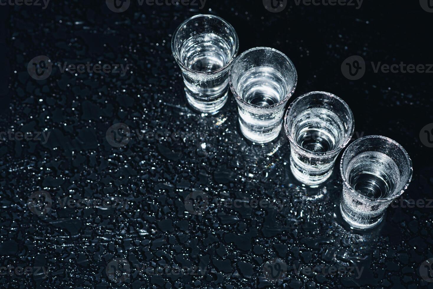 Vodka. Shots, glasses with vodka with ice .Dark background. Copy space .Selective focus. photo